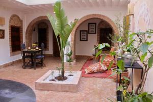 a living room filled with lots of plants and a table at La Maison Berber Shams in Marrakech