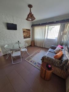 a living room with a couch and a table at Departamento Completo Centro Bariloche in San Carlos de Bariloche