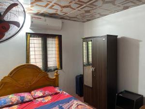 a bedroom with a bed with a wooden head board at thurai guest house in Jaffna