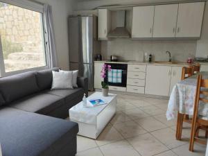 a living room with a couch and a kitchen at Baso Hilltop Apartments in Argassi
