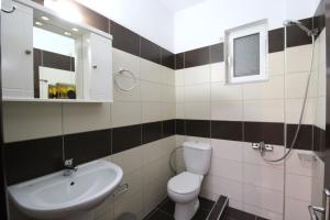 a bathroom with a sink and a toilet and a mirror at Vila Oscar in Ksamil +64 photos
