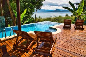 a deck with chairs and a swimming pool at Casa Lobo in San Pedro La Laguna