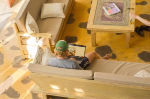 a person laying in a bunk bed with a laptop at Coffee Tree Boutique Hostel in Salento