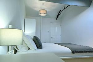 a white bedroom with a bed and a lamp at King Size City Centre En Suite Room with Parking in Preston