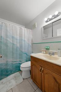 a bathroom with a toilet and a sink and a shower at Cocoa Beach Condo in Cocoa Beach