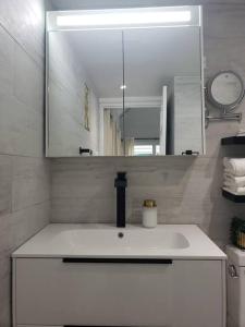 a bathroom with a white sink and a mirror at Via Sophia in Negril +10 photos