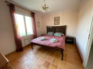 a bedroom with a bed with a pink comforter at Maison accueillante à Gémozac - 100 m² avec jardin fertile. in Gémozac