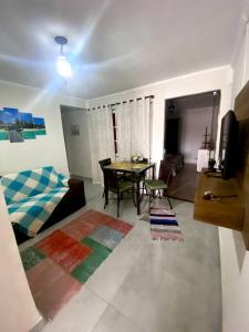 a living room with a table and a dining room at Porto Allegra in Cabo Frio