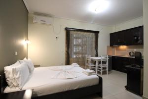 a bedroom with a white bed and a kitchen at Vila Oscar in Ksamil
