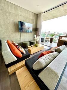a living room with two couches with pillows at Espectacular diseño, terraza con Hamaca y Jacuzzi in Guadalajara