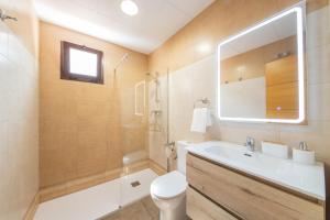 a bathroom with a sink and a toilet and a mirror at Apartamento El Museo Écija in Écija +66 photos