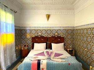 a bedroom with a bed with two dolls on it at Riad dar Assou in Marrakesh +63 photos