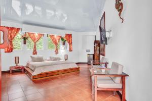 a bedroom with a bed and a table and a tv at Hotel Playa Bejuco in Esterillos Este