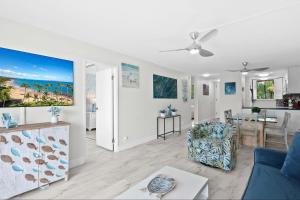 a living room with a blue couch and a kitchen at Kanai a Nalu 314 - Newly Renovated, Oceanfront, AC in Wailuku