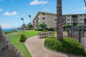 a patio with a table and chairs in front of a building at Kanai a Nalu 314 - Newly Renovated, Oceanfront, AC in Wailuku