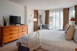 a bedroom with a bed and a tv on a dresser at 2BR plus den Ski in Ski out Condo with Pool and Hot Tub by Harmony Whistler in Whistler +37 photos