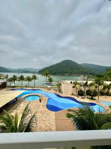 a view of a swimming pool with a view of the water at Quarto Porto Marina Mont Blanc Resort - Mangaratiba - Itacuruça Rj in Itacuruçá