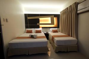 ein Hotelzimmer mit 2 Betten in einem Zimmer in der Unterkunft Southpole Central Hotel in Cebu City