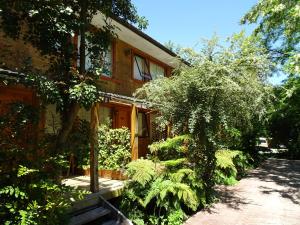 a house with a tree and plants in front of it at Espacio y Tiempo Hotel de Montaña in La Junta