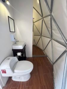 un baño con inodoro y lavabo en Glamping Cholula, en Cholula