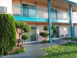 an apartment building with trees in front of it at Inns of California Salinas in Salinas