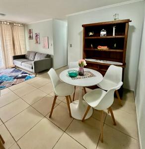 - un salon avec une table, des chaises et un piano dans l'établissement Depto Maximo en condominio central 3D 1B Parking Excelente Conectividad,Atención Empresas-Facturas, à Chillán