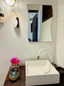 a white sink in a kitchen with a mirror at Pousada Tangerina in Icaraí