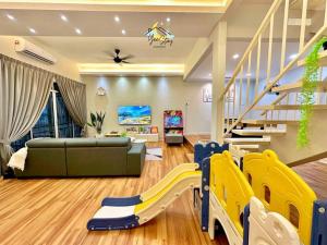 a living room with a couch and a slide at Kampung8 17pax Snooker Arcade in Melaka