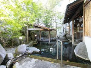 a pond in the yard of a house at Yufuin Besso Shikisai Hotel in Yufu