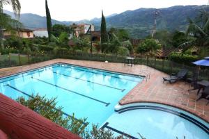 a large swimming pool with a view of the mountains at Casa Familiar y Naturaleza en Parcelación Privada in Amagá