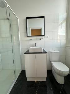 a bathroom with a toilet and a sink and a mirror at ARK Apartments in Echuca +9 photos