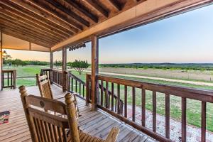 un porche avec deux chaises et une vue sur un champ dans l'établissement Appian Way Avalon Cottage, à Fredericksburg 7 autres photos