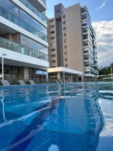 a large swimming pool in front of a building at Apartamento Tulum Bertioga in Bertioga