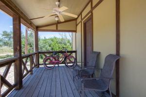 a bike parked on a porch with two chairs at Appian Way Oliva Cottage in Fredericksburg