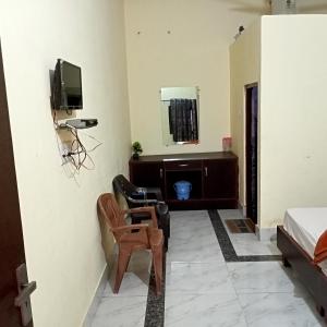 a room with a tv and a couch and a chair at Jyotis home stay Khajuraho in Khajurāho