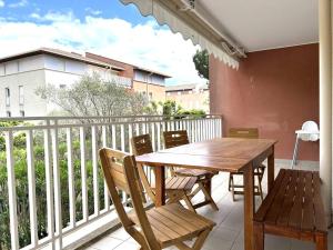 une table et des chaises en bois sur un balcon dans l'établissement Appartement moderne 4 pièces à Cavalière, proche plage - FR-1-251-826, au Lavandou