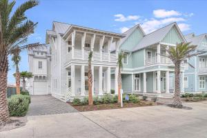 Una gran casa blanca con palmeras delante. en Isle Be Back 238 LAK, en Mustang Beach