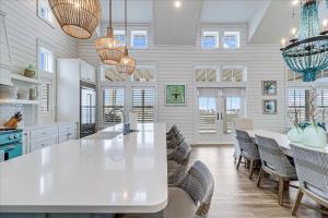 una cocina con una gran mesa blanca y sillas en Isle Be Back 238 LAK, en Mustang Beach