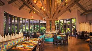 a dining room with tables and chairs and windows at Disney's Animal Kingdom Lodge in Orlando