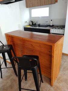 une cuisine avec un comptoir en bois avec un évier et une cuisinière dans l'établissement Cabaña - San Martin de los Andes, à San Martín de los Andes