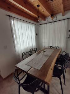 - une table en bois avec des chaises dans l'établissement Cabaña - San Martin de los Andes, à San Martín de los Andes