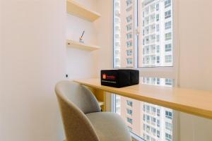 una scrivania con due sedie davanti a una finestra di Simply Look and Cozy Studio Tokyo Riverside PIK 2 Apartment By Travelio a Rawalembang