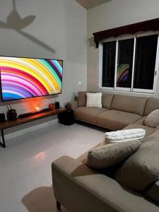 ein Wohnzimmer mit einem Sofa und einem Regenbogen auf dem Fernseher in der Unterkunft Casita Cacao Canela in Villahermosa