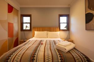 a bedroom with a large bed with two windows at Family Camping Paradise with Kangaroos and Nature in Greta