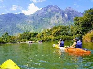 a group of people in a kayak on a river at Champa House in Vang Vieng