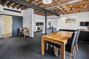 a dining room with a wooden table and black chairs at Gibson Mill waterfront warehouse apartment - 201 in Hobart