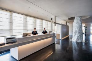 two people sitting at a reception desk in a lobby at Atour S Hotel Chongqing Yubei Central Park in Yubei