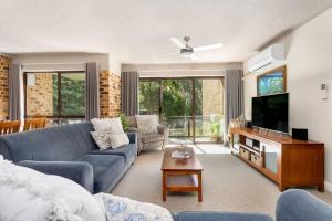 a living room with a couch and a tv at Bay Parklands 44 WI FI Netflix Air Con and Views in Nelson Bay