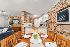 a dining room with a table and a couch at Bay Parklands 44 WI FI Netflix Air Con and Views in Nelson Bay