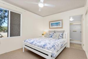 a white bedroom with a bed and a window at Bay Parklands 44 WI FI Netflix Air Con and Views in Nelson Bay +24 photos